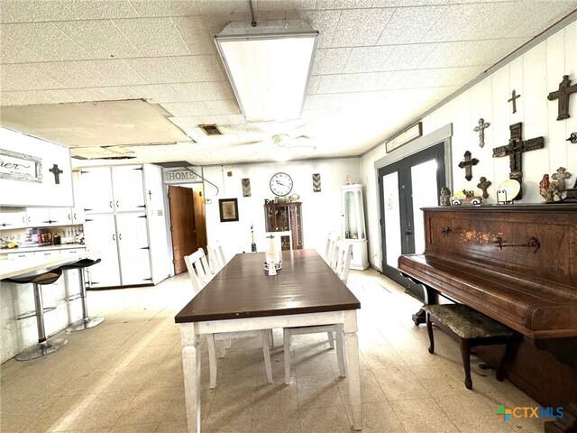 interior space with a paneled ceiling and french doors