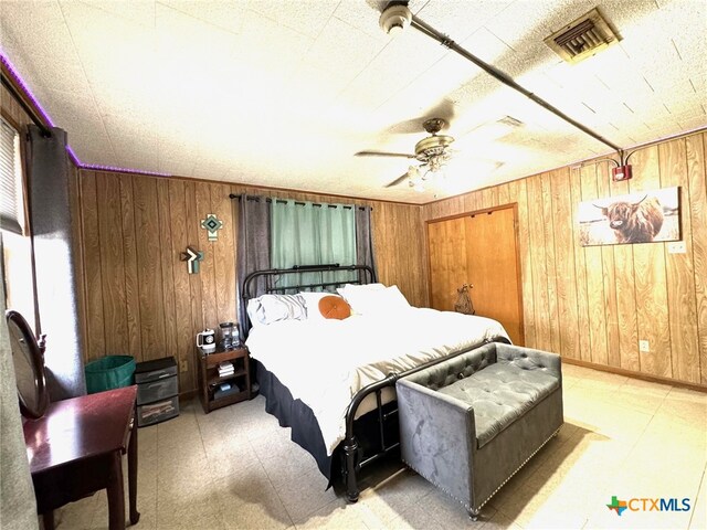 bedroom featuring wood walls and ceiling fan