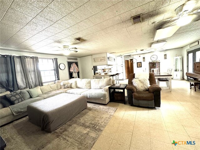 living room featuring ceiling fan and plenty of natural light