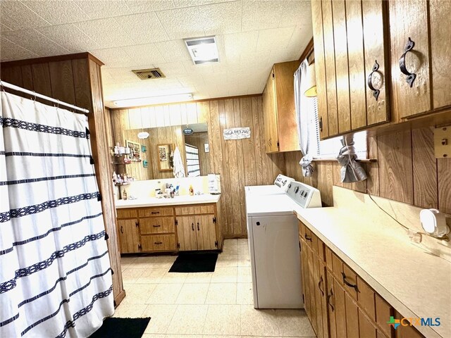 interior space with cabinets, wooden walls, and separate washer and dryer