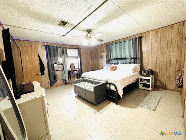 bedroom with wood walls and ceiling fan