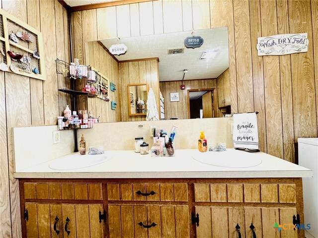 bathroom with vanity and wooden walls