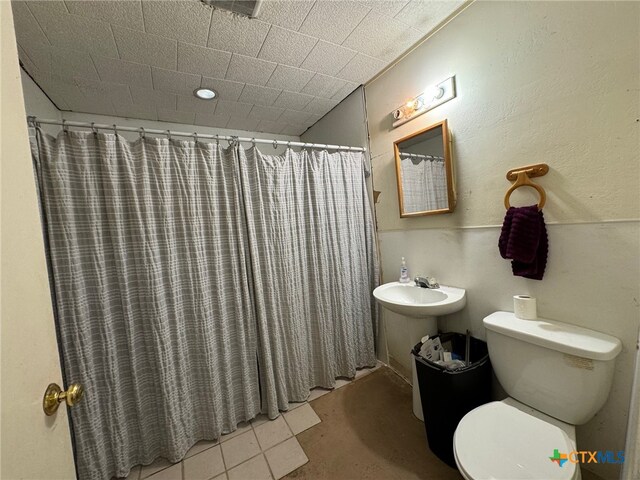 bathroom with tile patterned flooring, curtained shower, and toilet