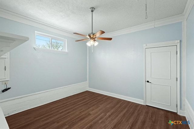 spare room featuring wood finished floors, a textured ceiling, attic access, and ornamental molding