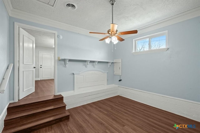 unfurnished living room featuring visible vents, ceiling fan, ornamental molding, wood finished floors, and a textured ceiling