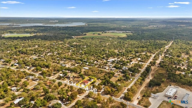 birds eye view of property featuring a forest view and a water view