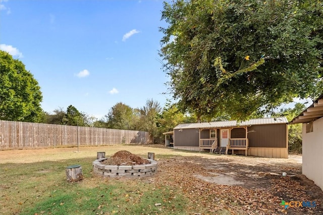 view of yard with a fire pit and fence