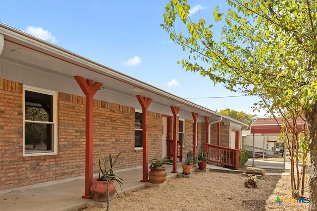 exterior space featuring a porch and brick siding