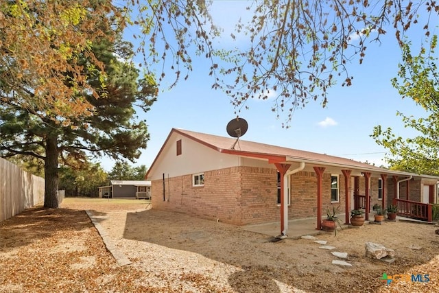 view of home's exterior featuring brick siding and fence