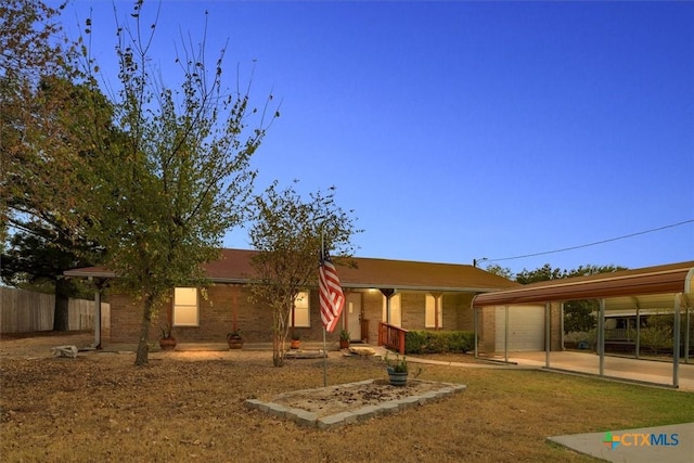 view of front of property featuring a detached carport, fence, and brick siding