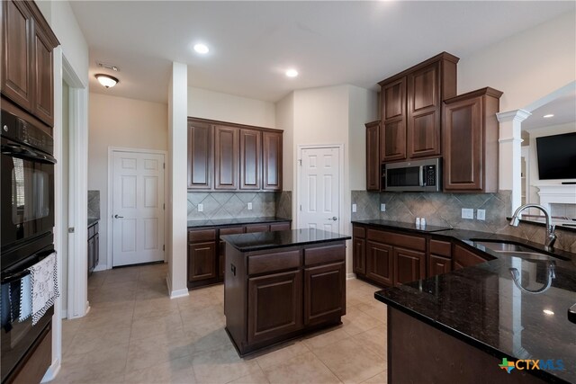 115 Scarlet Ct, Canyon Lake, TX 78133 - kitchen featuring dark stone countertops, stainless steel microwave, decorative backsplash, decorative columns, and a sink