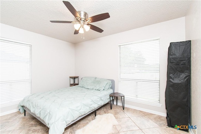 812 Trail Crest Dr, Harker Heights, TX 76548 - bedroom with light tile patterned floors, baseboards, ceiling fan, and a textured ceiling