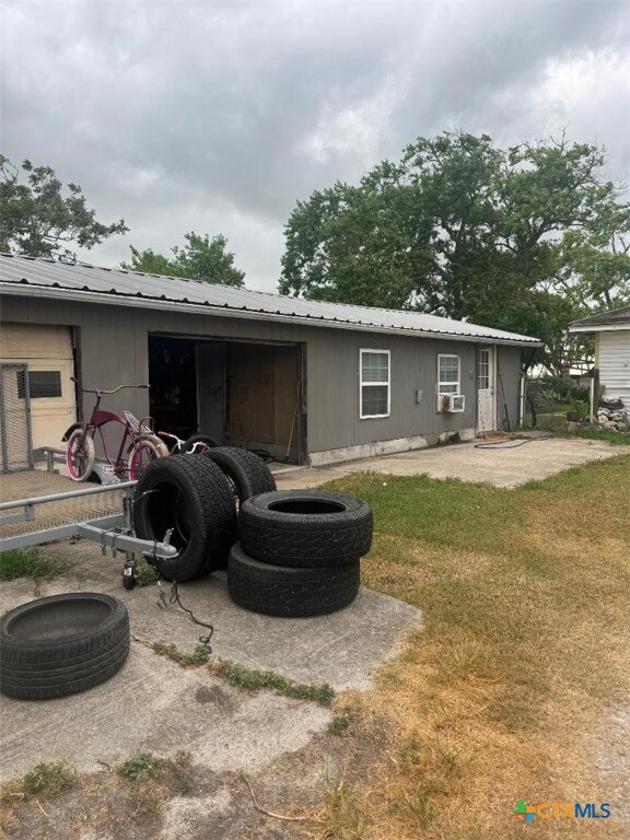 rear view of property with a patio and a lawn