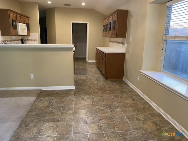 109 Hidden Mesa, Cibolo, TX 78108 - kitchen featuring white microwave, tasteful backsplash, recessed lighting, light countertops, and a peninsula