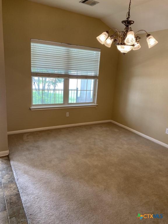 109 Hidden Mesa, Cibolo, TX 78108 - spare room featuring a chandelier, vaulted ceiling, and dark colored carpet