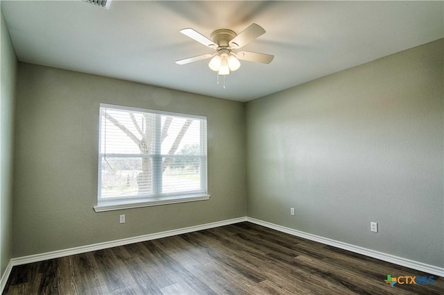 unfurnished room featuring dark wood-style floors, ceiling fan, and baseboards