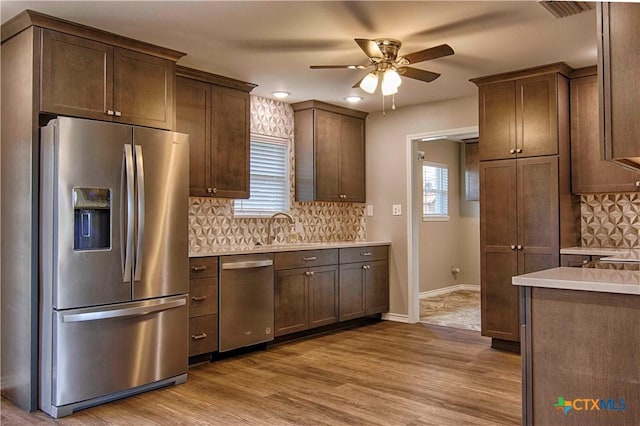 kitchen featuring decorative backsplash, appliances with stainless steel finishes, light countertops, and wood finished floors