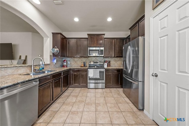 406 Coby, Troy, TX 76579 - kitchen with stainless steel appliances, dark brown cabinets, light stone counters, tasteful backsplash, and light tile patterned floors