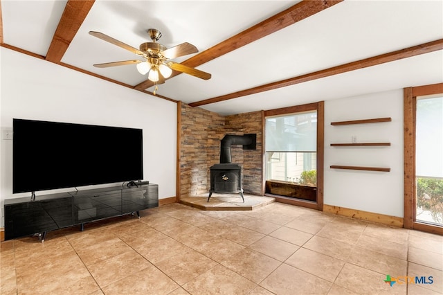 216 E Cedar St, Seguin, TX 78155 - unfurnished living room with a wood stove, beam ceiling, light tile patterned floors, a ceiling fan, and baseboards