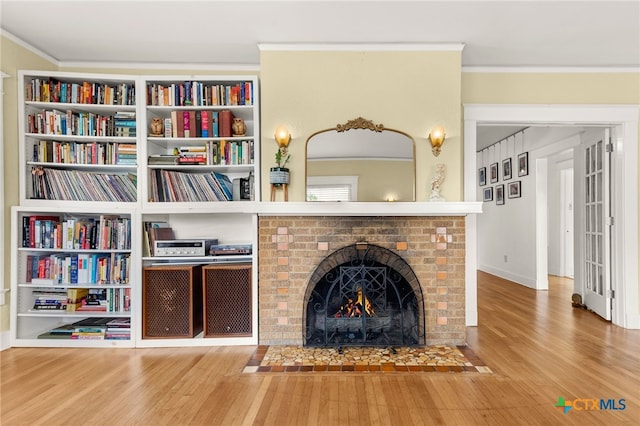216 E Cedar St, Seguin, TX 78155 - unfurnished living room featuring wood finished floors, ornamental molding, and a brick fireplace
