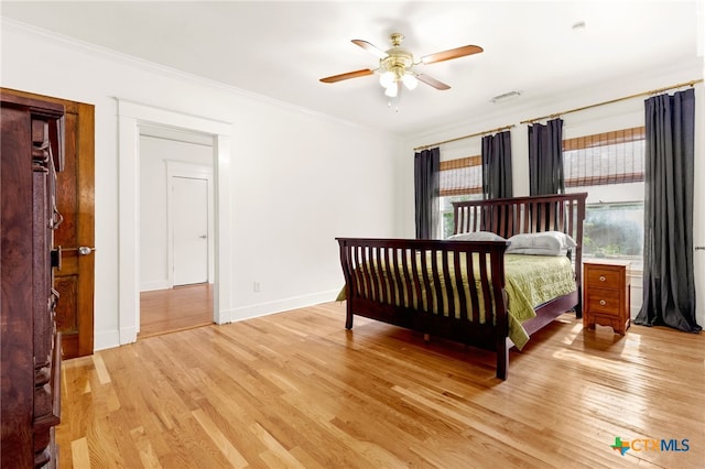 216 E Cedar St, Seguin, TX 78155 - bedroom featuring light wood-style floors, crown molding, baseboards, and a ceiling fan