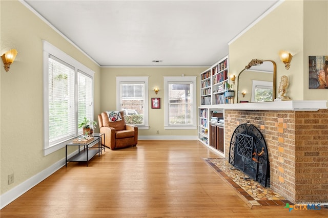 216 E Cedar St, Seguin, TX 78155 - living area with ornamental molding, wood finished floors, a brick fireplace, and baseboards