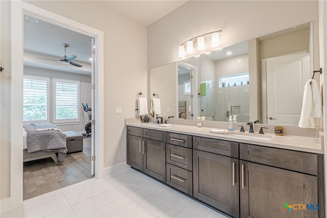 433 Skipping Cedar St, San Marcos, TX 78666 - ensuite bathroom with a stall shower, a ceiling fan, double vanity, tile patterned flooring, and baseboards
