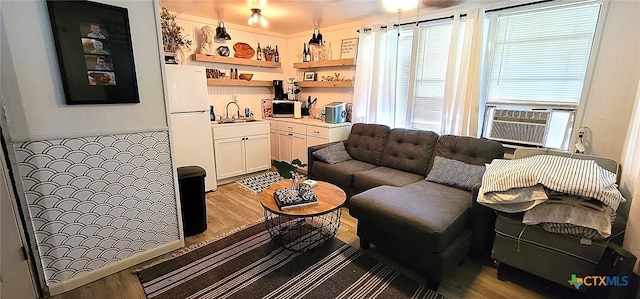 living area with wood finished floors and cooling unit