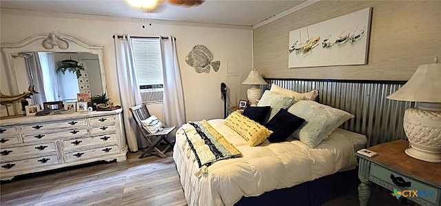 bedroom with crown molding, a ceiling fan, and wood finished floors
