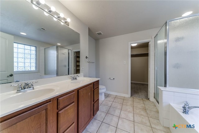 full bathroom featuring a garden tub, a stall shower, tile patterned flooring, and a sink