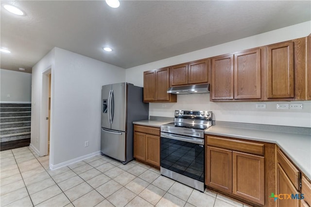 kitchen featuring brown cabinets, under cabinet range hood, appliances with stainless steel finishes, and light countertops