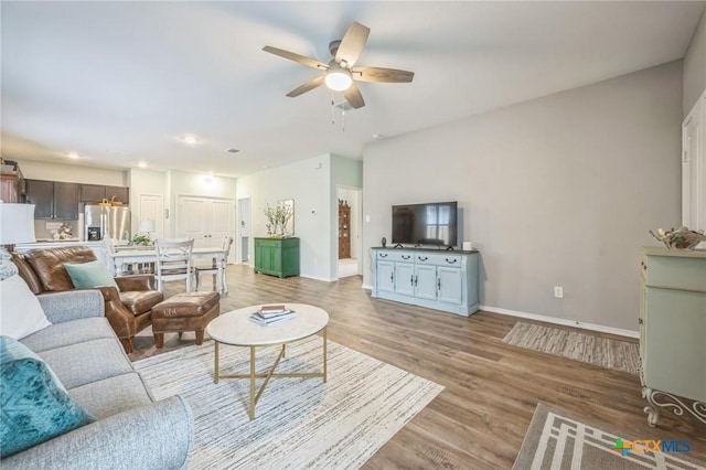 living area with baseboards, recessed lighting, light wood finished floors, and ceiling fan