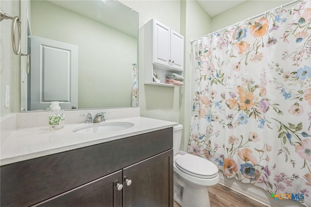 bathroom with vanity, shower / bathtub combination with curtain, wood finished floors, and toilet