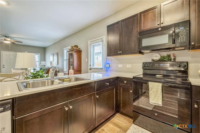 kitchen with dark brown cabinetry, ceiling fan, light countertops, a sink, and black appliances