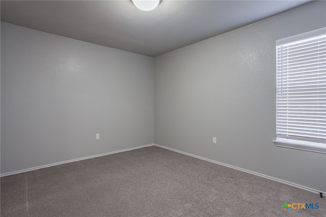 unfurnished room featuring carpet flooring and a textured ceiling