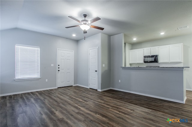 unfurnished living room featuring ceiling fan, lofted ceiling, and dark wood-type flooring