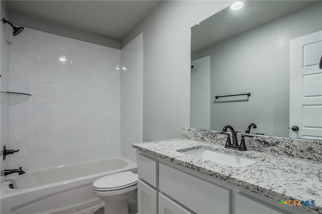 full bathroom with vanity, tiled shower / bath combo, and toilet