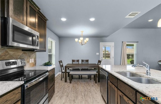 832 Paseo Del Plata, Temple, TX 76502 - kitchen featuring stainless steel appliances, a chandelier, light wood-style flooring, dark brown cabinetry, and hanging light fixtures