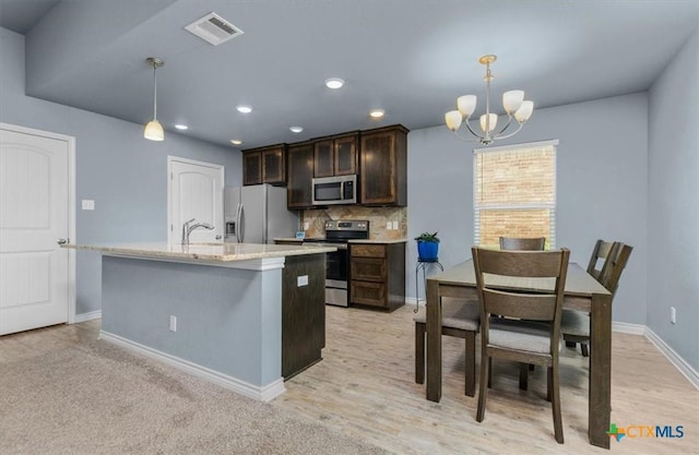 832 Paseo Del Plata, Temple, TX 76502 - kitchen with appliances with stainless steel finishes, dark brown cabinets, a chandelier, decorative backsplash, and hanging light fixtures