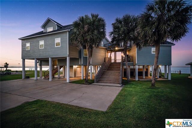 view of front of house featuring a lawn, covered porch, and a carport