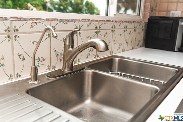 room details featuring white cabinets and sink