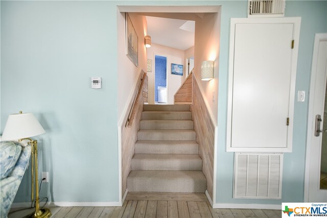 stairs featuring hardwood / wood-style floors