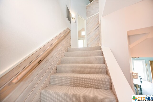 staircase featuring tile walls