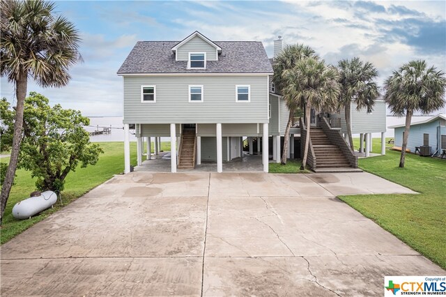 raised beach house with a carport and a front lawn