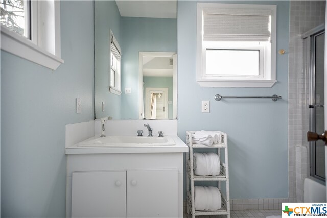 bathroom with enclosed tub / shower combo and vanity