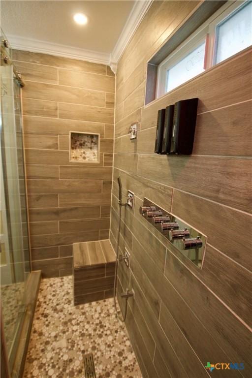 bathroom with ornamental molding and a tile shower