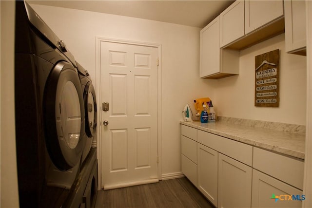 laundry room with cabinets, dark hardwood / wood-style floors, and washing machine and clothes dryer