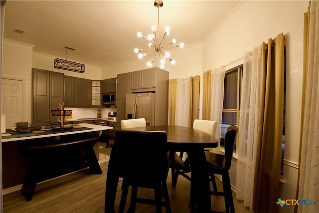 dining space featuring ornamental molding, dark hardwood / wood-style floors, and an inviting chandelier