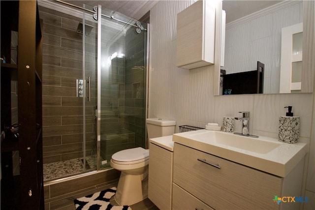 bathroom with vanity, a shower with shower door, ornamental molding, and toilet