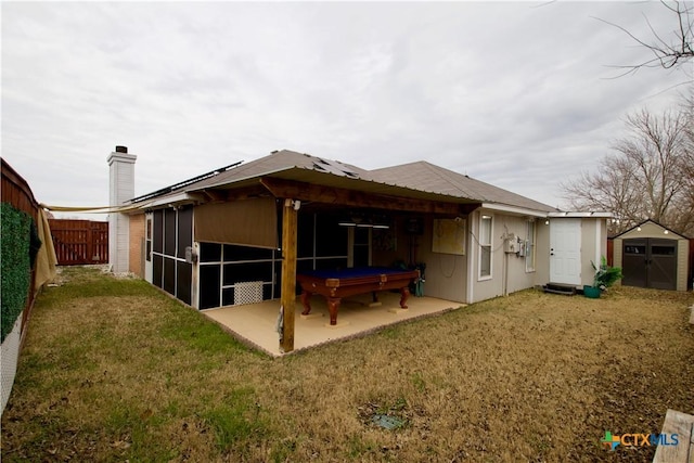 back of property featuring a storage unit, a patio area, and a lawn